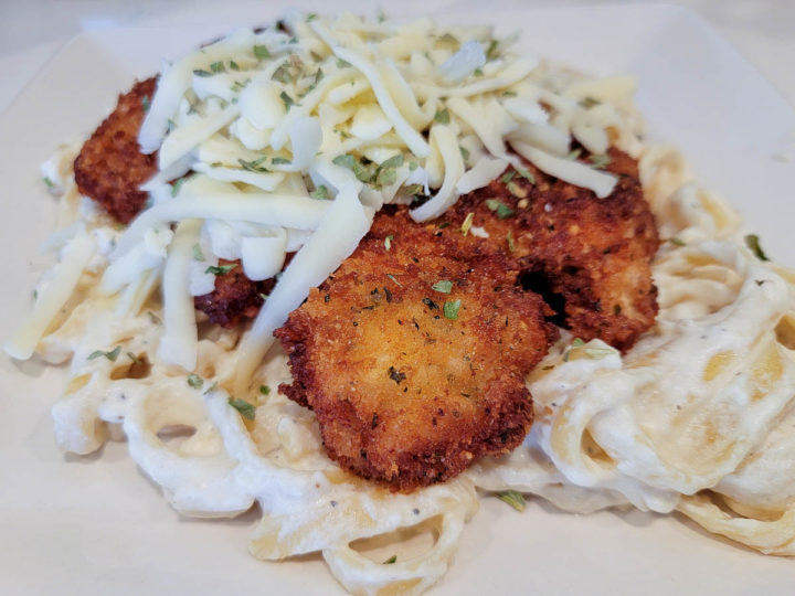 crispy panko fried chicken over pasta and topped with shredded cheese.