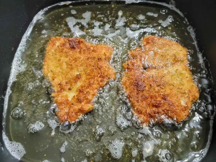 panko breaded chicken frying in oil.