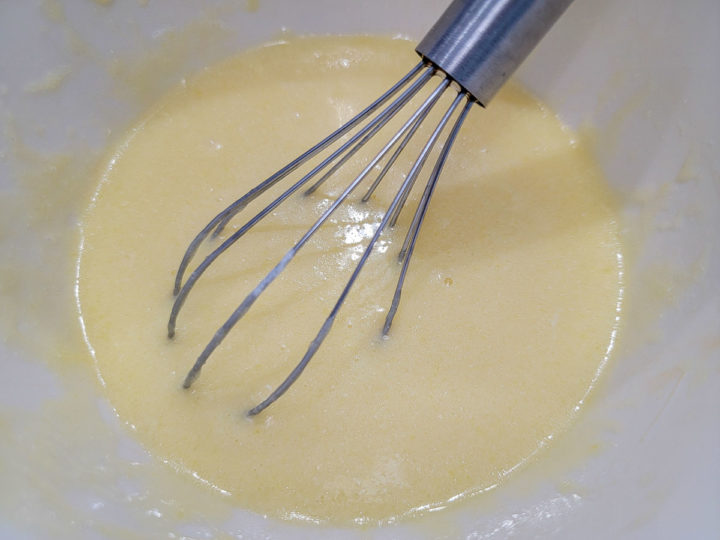 sugar, egg, oil, melted butter, sour cream, whole milk, and vanilla whisked in a bowl.