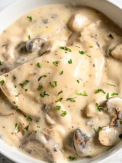 baked pierogi, chicken, mushrooms, and creamy sauce in a serving bowl.