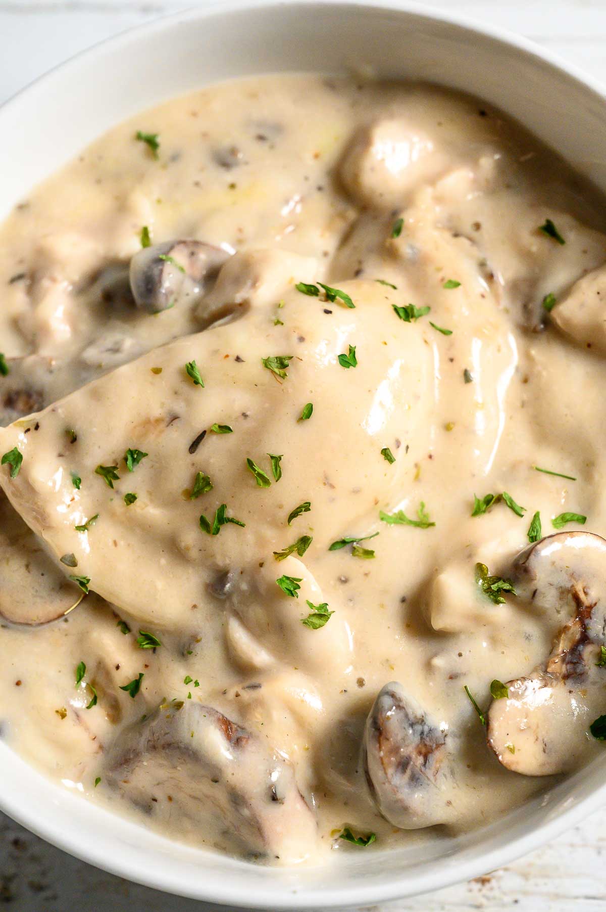 baked pierogi, chicken, mushrooms, and creamy sauce in a serving bowl.