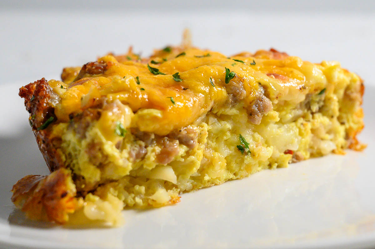 a slice of tater tot breakfast casserole filled with crispy tater tots, gooey cheese, savory sausage, and fluffy eggs.