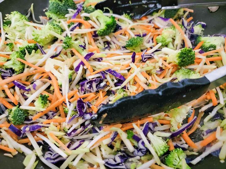 garlic and broccoli slaw cooking in a pan.