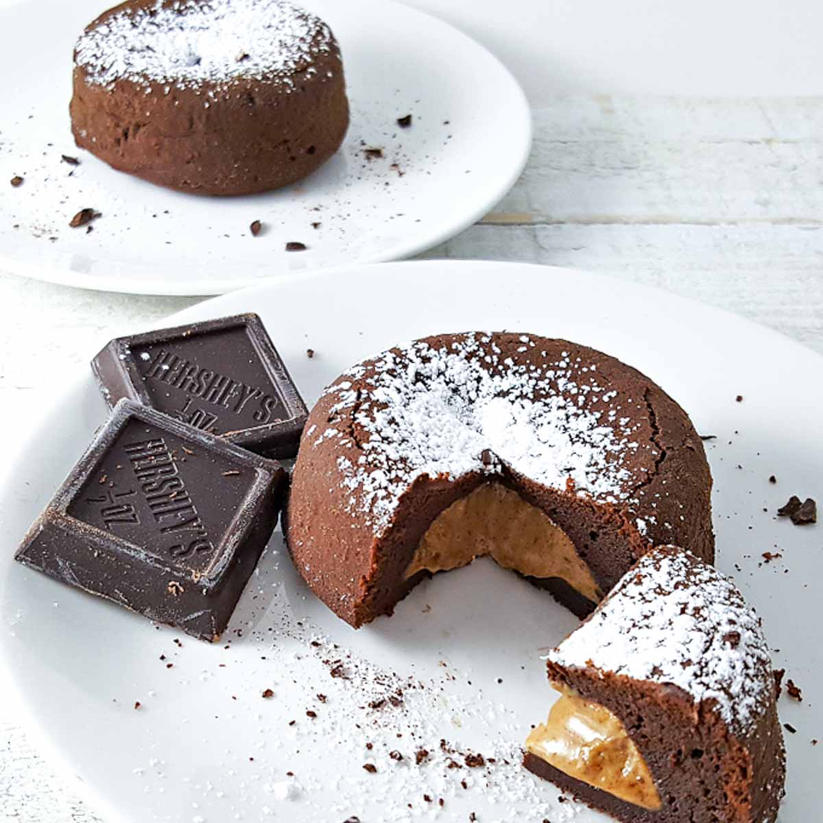 two peanut butter chocolate lava cakes on two plates.