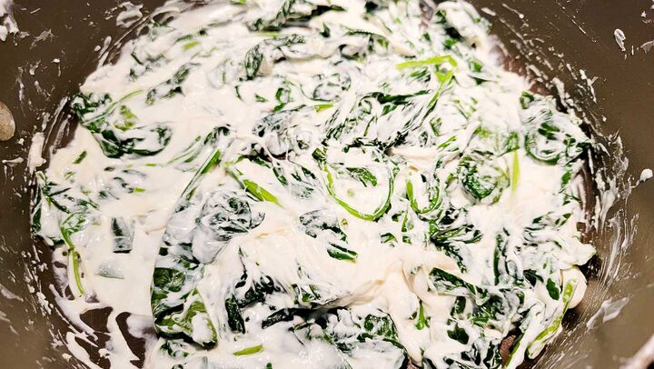 cream cheese and spinach cooking in a pan.