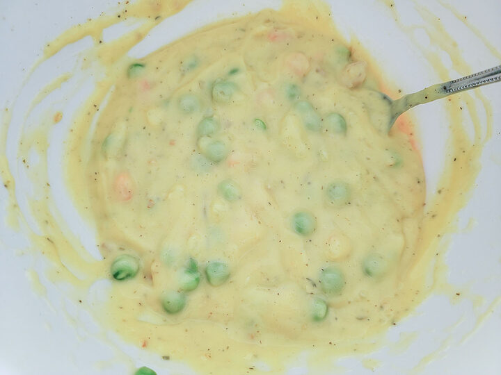 chicken, peas, carrots, and creamy sauce in a bowl.